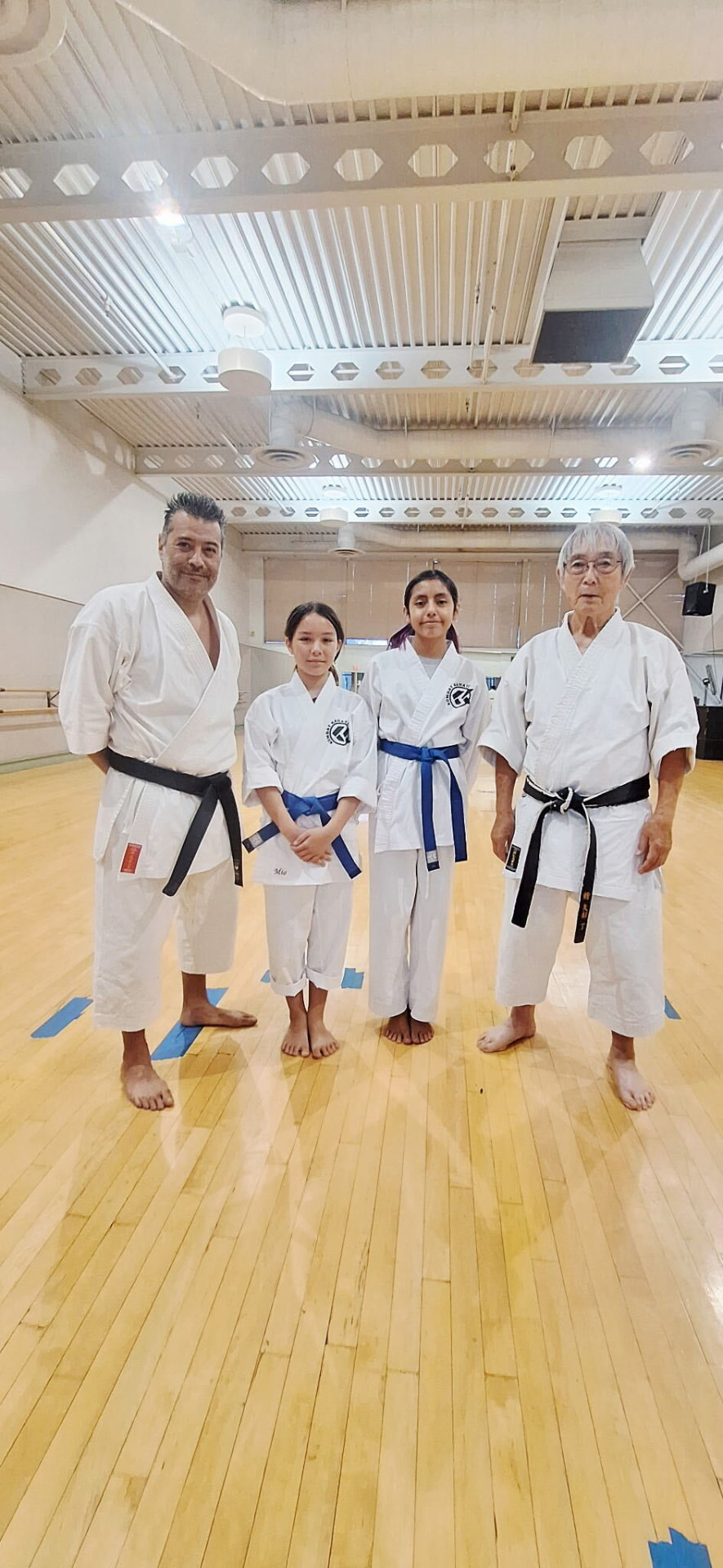 Sensei Ryan and Sensei James Yabe with two Kombat Karate students in gis at the Long Beach dojo